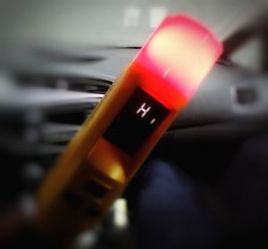 Urządzenie do badania trzeźwości, wskazujące wynik HI oraz zaświecona lampka czerwona w tym urządzeniu.