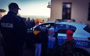Policjant prezentuje dzieciom radiowóz