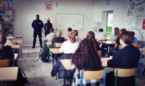 Policjant i policyjny profilaktyk na spotkaniu z młodzieżą w szkole
