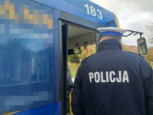 Umundurowany policjant kontroluje autobus MPK