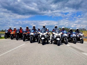 Ustawieni obok siebie policyjni motocykliści i ratownicy medyczni na motocyklach