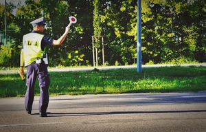 Policjant dający znaki lizakiem do zatrzymania się pojazdu