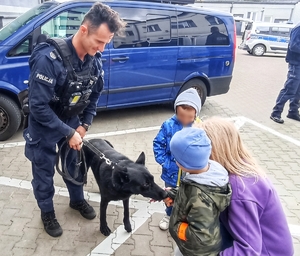 Policjant z psem służbowym oraz przedszkolakami