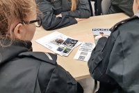 Wizyta w Komendzie Miejskiej Policji w Łomży.  Na zdjęciu widoczne są ulotki i materiały promujące zawód policjanta.