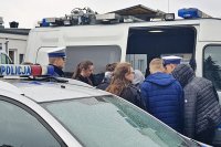 Wizyta w Komendzie Miejskiej Policji w Łomży.  Na zdjęciu grupka młodzieży ogląda wnętrze radiowozu policyjnego.