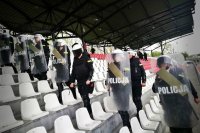 Ćwiczenia na stadionie, na zdjęciu widoczni policjanci z tarczami z napisem Policja, którzy obecni są pomiędzy siedziskami stadionu.