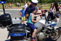 Pokaz sprzętu policyjnego. Policjant Wydziału Ruchu Drogowego pokazuje motocykl.