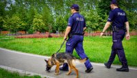 Patrol Policji z psem służbowym podczas pracy na terenie terenów rekreacyjnych w Łomży