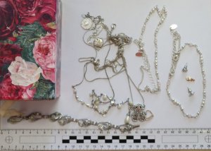 Pudełko tekturowe w kwiaty z zawartością srebrnej biżuterii: łańcuszki, bransoletka, kolczyki