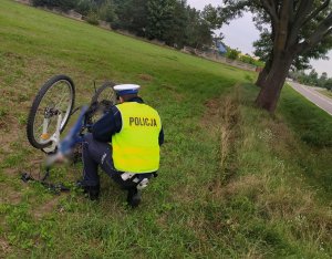 Umundurowany policjant, który wykonuję oględziny roweru
