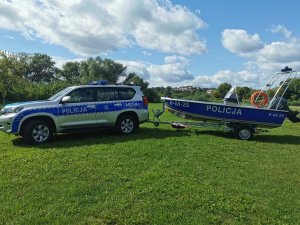 Radiowóz policyjny i  policyjna łódka.