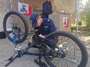 Umundurowany policjant znakuje rower.