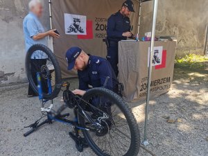 Umundurowany policjant znakuje rower.