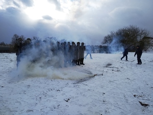 Policjanci szkolą żołnierzy na zaśnieżonym polu.
