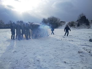 Policjanci szkolą żołnierzy na zaśnieżonym polu.