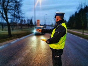 Umundurowany policjant wskazuje miejsce zatrzymania kierowcy