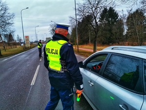 Umundurowany policjant bada trzeźwość kierowcy