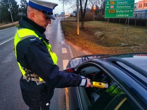Umundurowany policjant bada na stan trzeźwości kierowcę