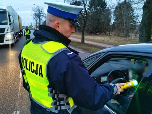 Umundurowany policjant bada na stan trzeźwości kierowcę