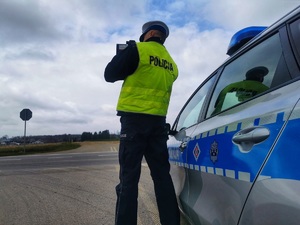 Policjant mierzy prędkość jadącym samochodom