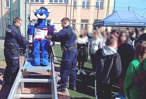 Policjanci i policyjna maskotka przy symulatorze zdarzeń