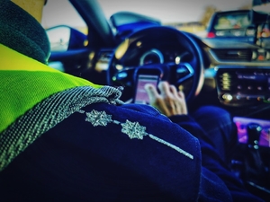Policjant sprawdzający kierowcę w bazie danych na urządzeniu mobilnym