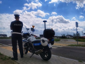 Policjant stojący obok służbowego motocykla