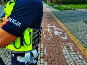 Umundurowany policjant stoi przy ścieżce dla pieszych.