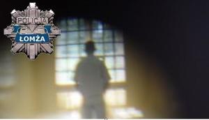 Kraty w oknie, przy której stoi postać i policyjna odznaka z napisem policja Łomża