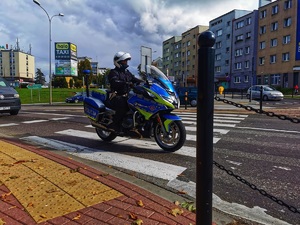 Policjant na motocyklu przejeżdża przez przejście dla pieszych