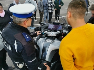 Policjant pokazuje motocykl służbowy