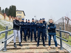 Umundurowane policjantki i dwie w ubraniu cywilnym, w kamizelkach z napisem policja stoją na schodach kamiennych.