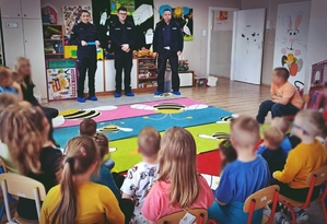 Policjantka i dwóch policjantów na spotkaniu w przedszkolu z dziećmi