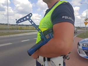 policjant trzyma urządzenie do pomiaru prędkości