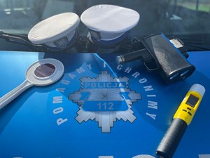 czapka policyjna, tarcza do zatrzymywania pojazdów i urządzenie do badania trzeźwości na masce radiowozu