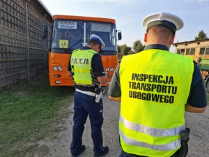 policjant funkcjonariusz Inspekcji Transportu Drogowego sprawdza autokar