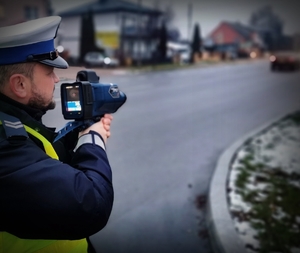 policjant mierzy prędkość miernikiem prędkości