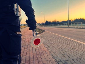 policjant zatrzymujący pojazd za pomocą &quot;lizaka&quot;