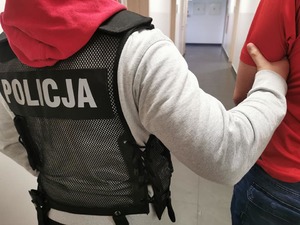 policjant prowadzi zatrzymanego