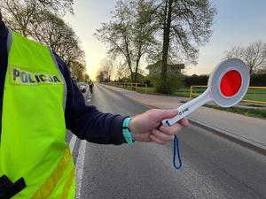 policjant z tarcza do zatrzymywania pojazdów