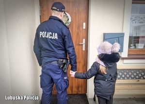 policjant trzyma za rękę dziecko
