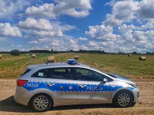 radiowóz na tle pola z belami