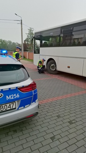 policjanci kontrolują kierowcę oraz autobus szkolny.