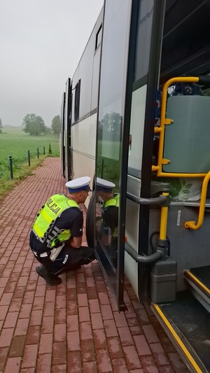 policjanci kontrolują kierowcę oraz autobus szkolny.