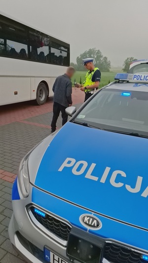 policjanci kontrolują kierowcę oraz autobus szkolny.
