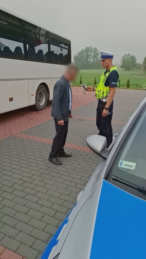 policjanci kontrolują kierowcę oraz autobus szkolny.