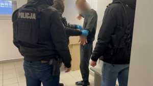 policjanci prowadzą zatrzymanego