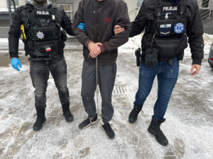 policjanci prowadzą zatrzymanego