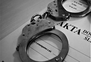 kajdanki leżące na aktach sprawy