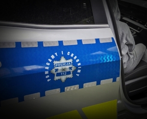 osoba cywilna siedząca w radiowozie